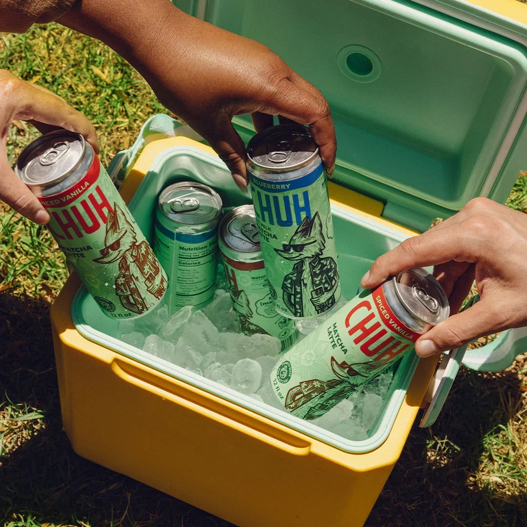Hands taking Chub soda cans out of a cooler filled with ice.